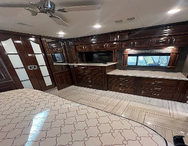 The TV, counter-space, large mirror, and window make this master bedroom for more than just sleeping in this diesel pusher for sale by owner
