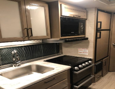 Modern kitchen is both elegant and functional, with plenty of space for more than one to cook in this great RV market value Thor motor coach
