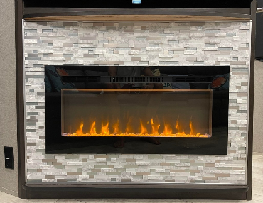 5th wheel RV has custom tile around fireplace near tv and kitchen making it one of a kind