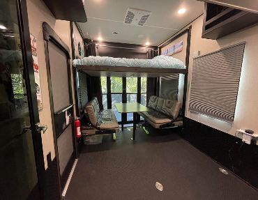 5th wheel rv has convertible booth and top bunk for eating and sleeping space